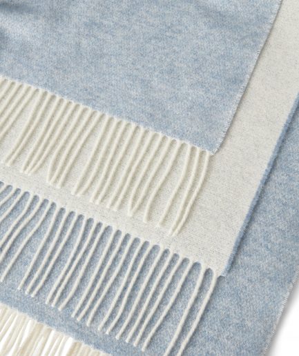 Close-up of a luxurious Merino & Cashmere two tone light blue plaid on a white backdrop.