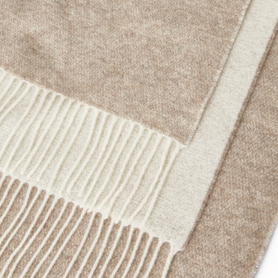 Close-up of a luxurious Merino & Cashmere two tone light taupe plaid on a white backdrop.