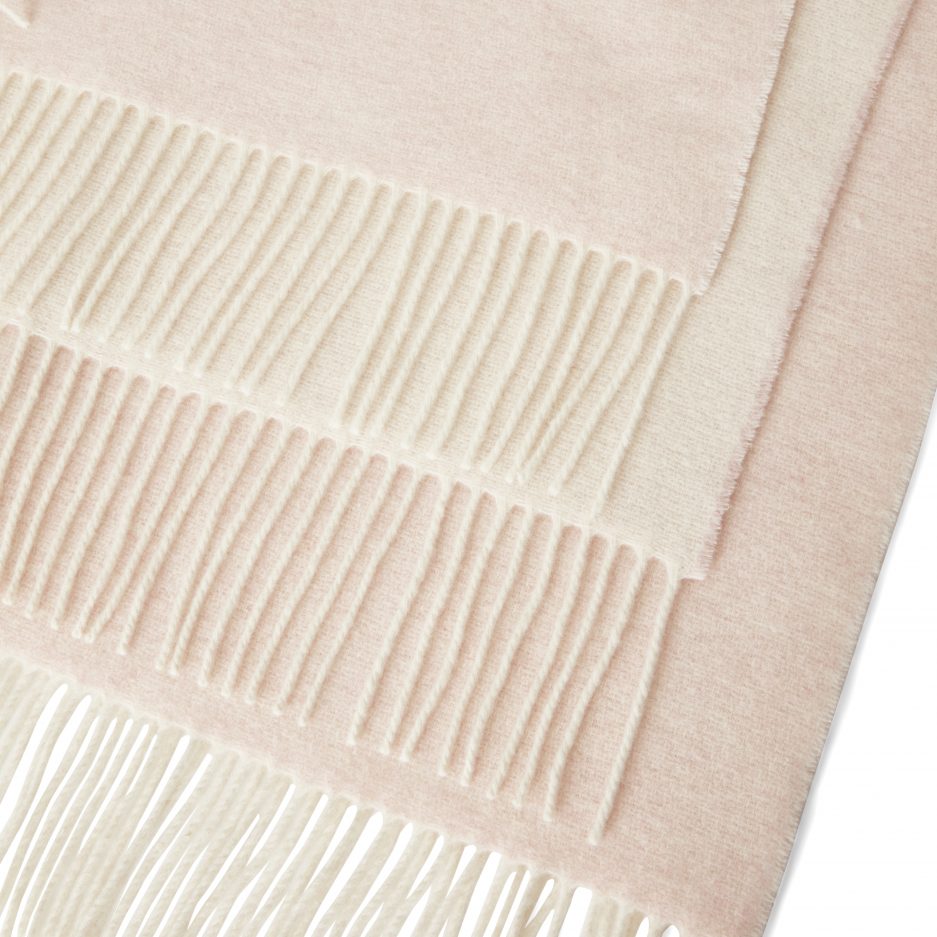 Close-up of a luxurious Merino & Cashmere two tone light rosé plaid on a white backdrop.