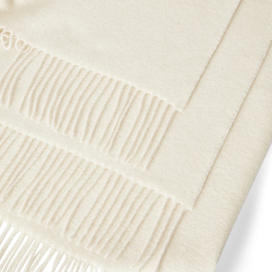 Close-up of a luxurious Merino & Cashmere two tone Offwhite plaid on a white backdrop.