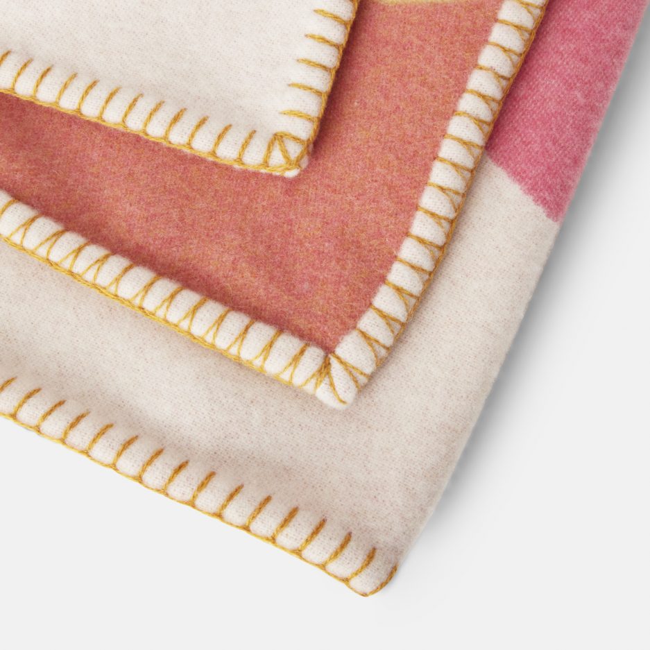 Close-up on a luxurious Modulo Ocra, Pink & Yellow wool plaid Designed with Rosehof Art Factory on a white backdrop.