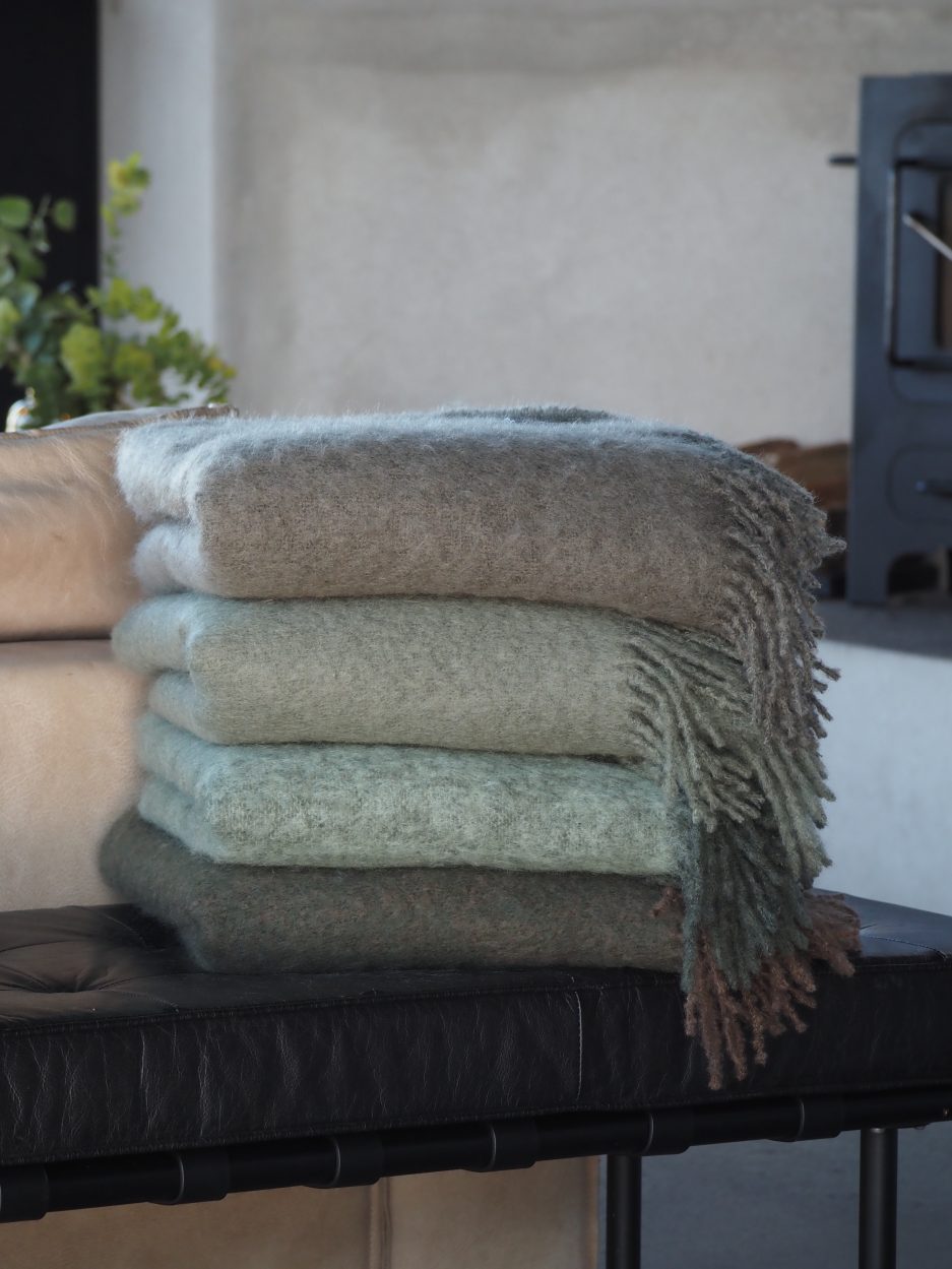 Four folded luxurious Mohair plaids in cold neutral colors stacked on top of each other.